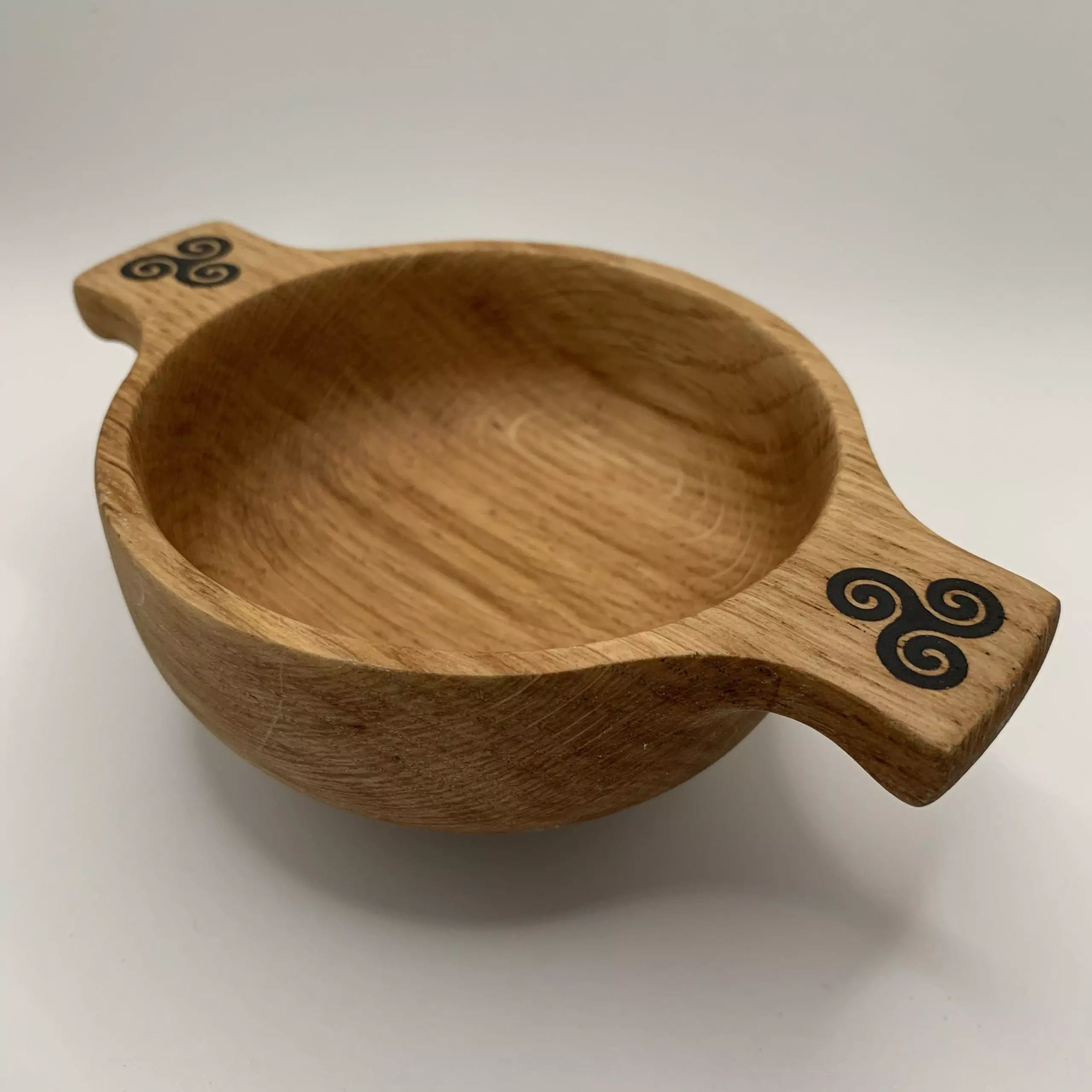 A beautiful wooden quaich handcrafted from locally sourced Scottish oak and engraved with a triskele design