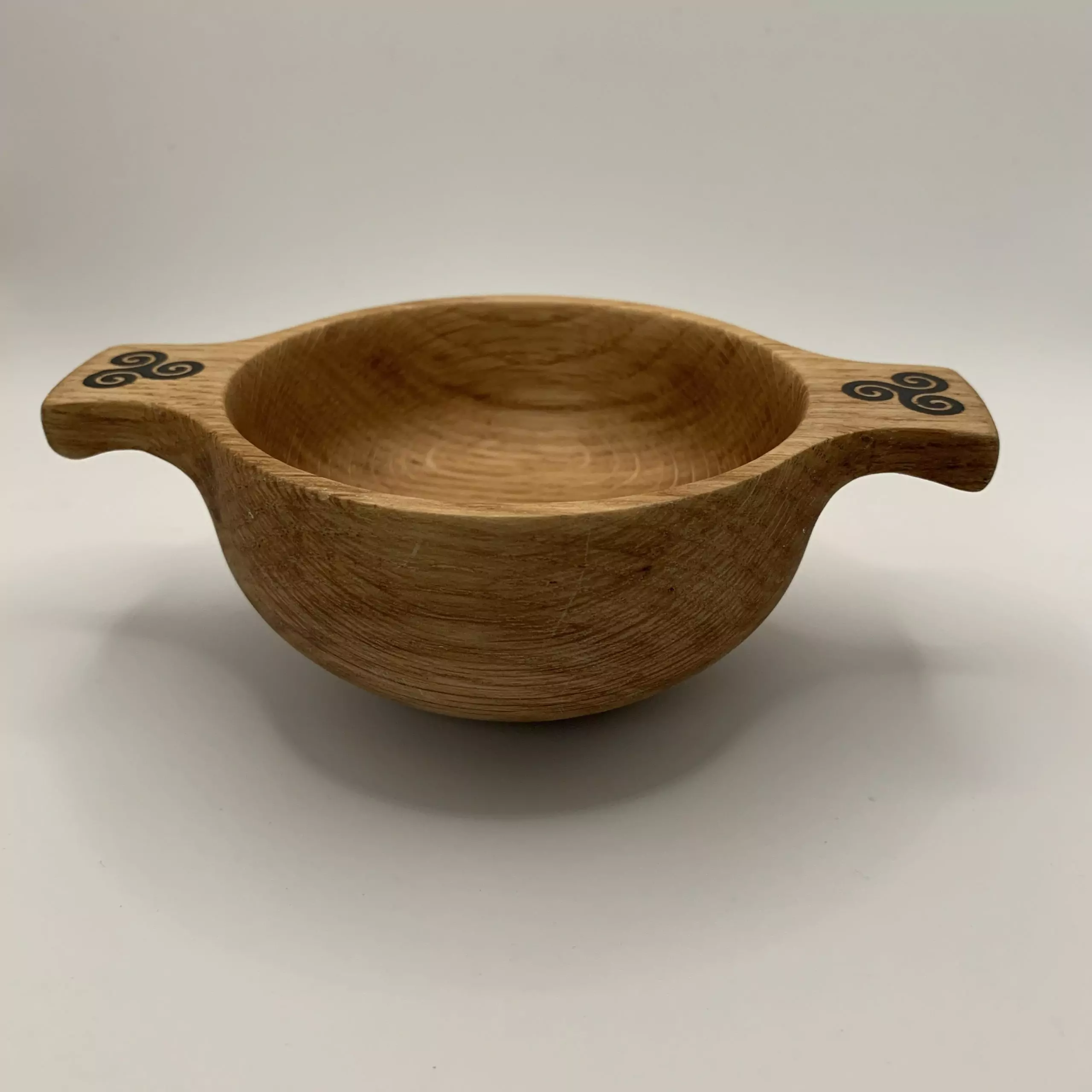 A beautiful wooden quaich handcrafted from locally sourced Scottish oak and engraved with a triskele design
