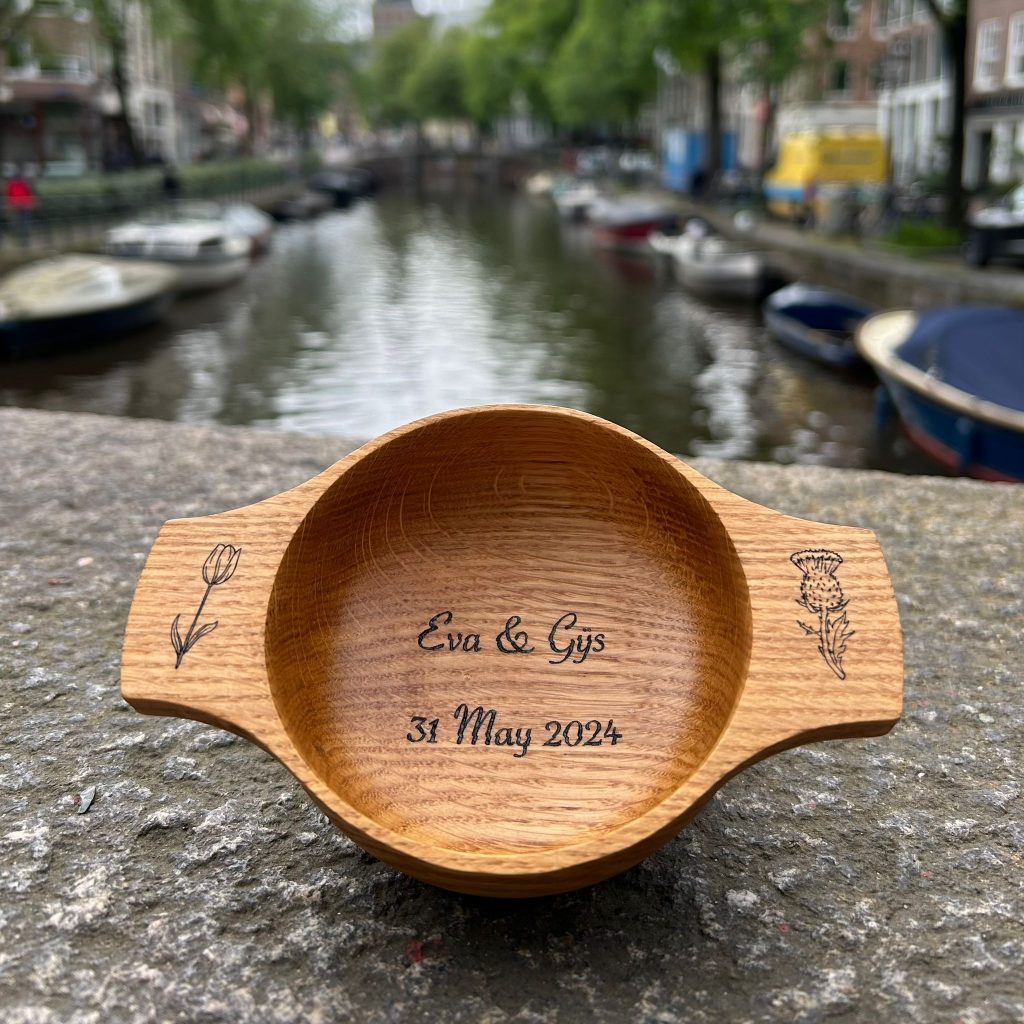 Custom wedding quaich for Dutch couple pictured against the backdrop of Amsterdam's canals
