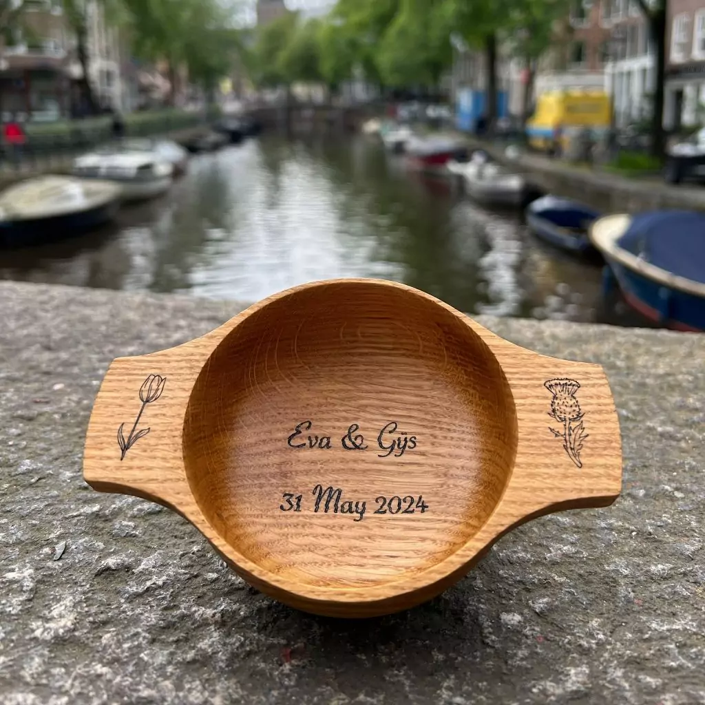 Custom wedding quaich for Dutch couple pictured against the backdrop of Amsterdam's canals