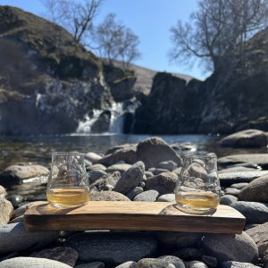 Oak whisky stave drink set with 2 spey tasting glasses set against the backdrop of a Scottish Highland waterfall